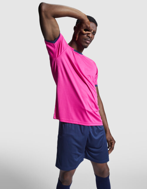 Mand i lyserød sports trøje og blå shorts