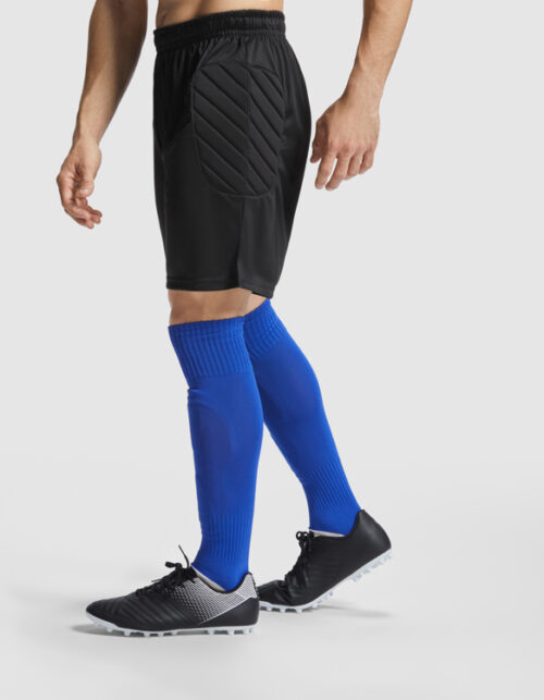 Mand i fodboldshorts og blå sokker