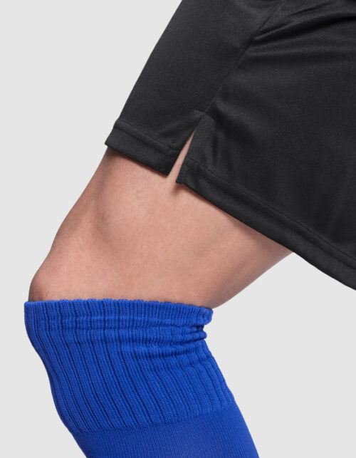 Fodboldspiller iført blå strømper og sorte shorts