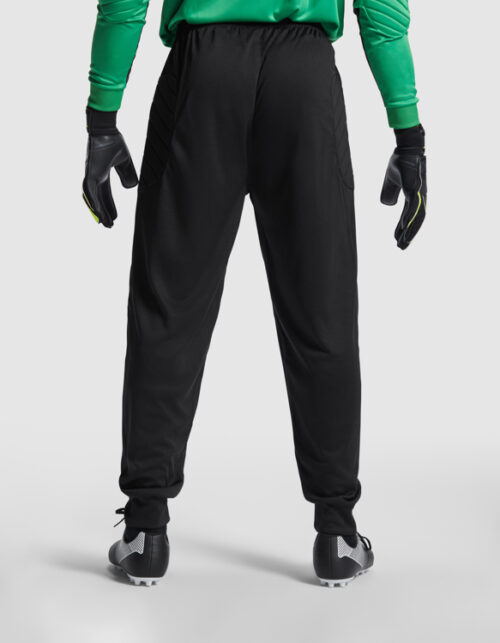 Mand i grønt tøj og sorte bukser, set bagfra.