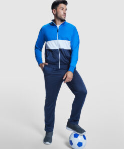 Man in tracksuit posing with soccer ball