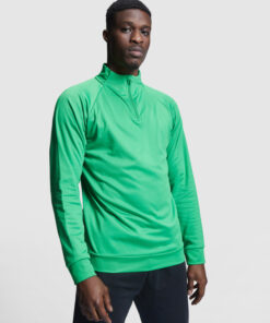 Man wearing green long-sleeve shirt, standing.