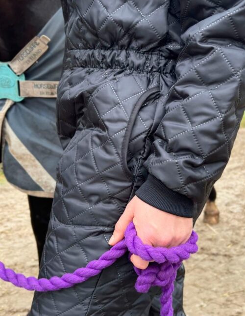 Person holder lilla reb ved siden af hest