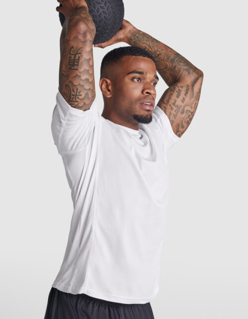 Mand træner med medicinbold, iført hvid trøje.