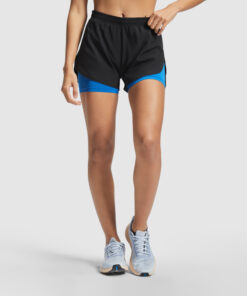 Kvinde iført løbeshorts og sneakers, klar til træning.