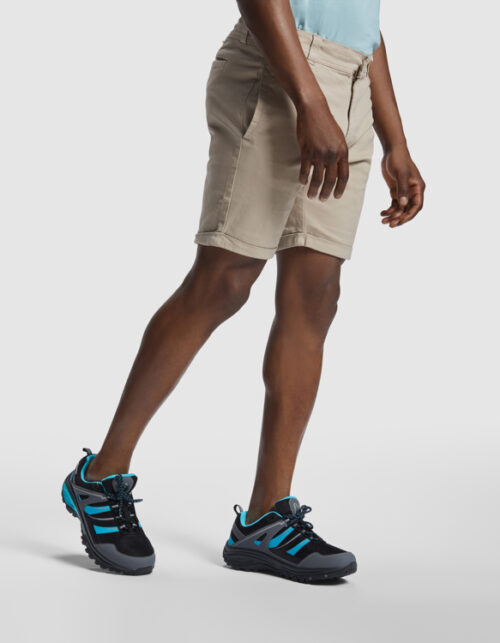 Mand iført beige shorts og blå vandresko