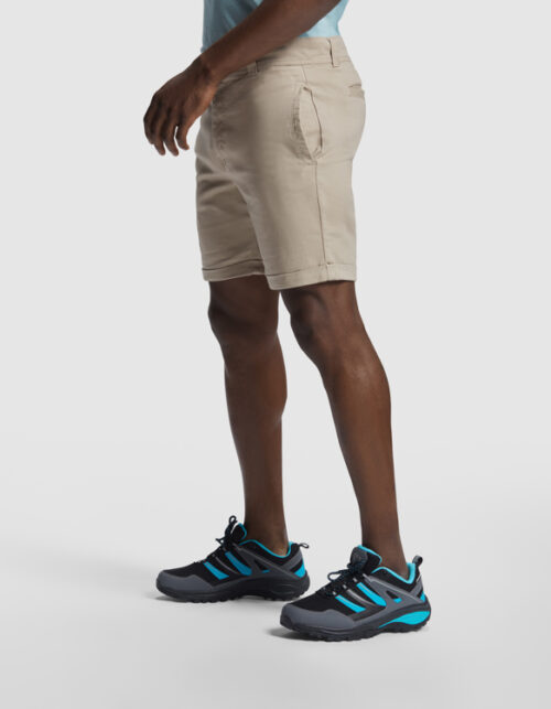 Mand iført beige shorts og sorte løbesko