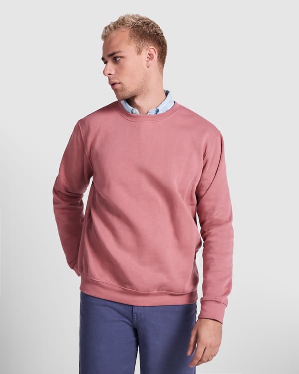 Mand i lyserød sweatshirt og blå bukser