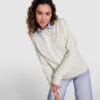 Kvinde i lys sweatshirt og jeans poserer