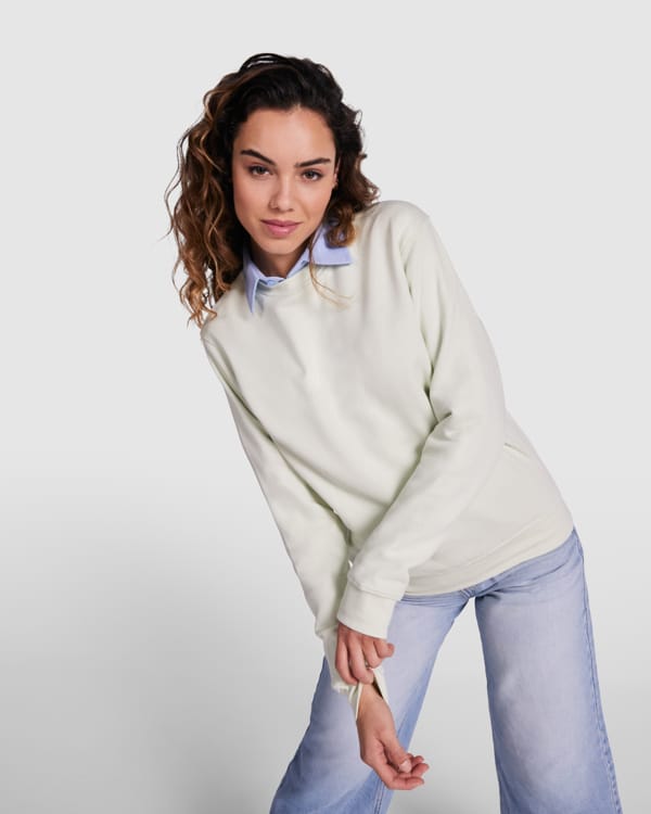 Kvinde i lys sweatshirt og jeans poserer