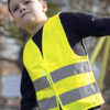 Dreng iført gul refleksvest udendørs