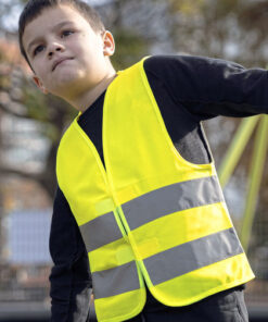 Dreng iført gul refleksvest udendørs