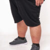 Person i sorte shorts og grå sneakers