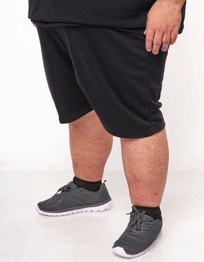 Person i sorte shorts og grå sneakers
