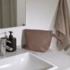 Toilettaske på badeværelsesvask ved siden af sæbedispenser