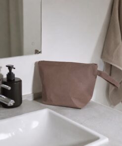 Toilettaske på badeværelsesvask ved siden af sæbedispenser