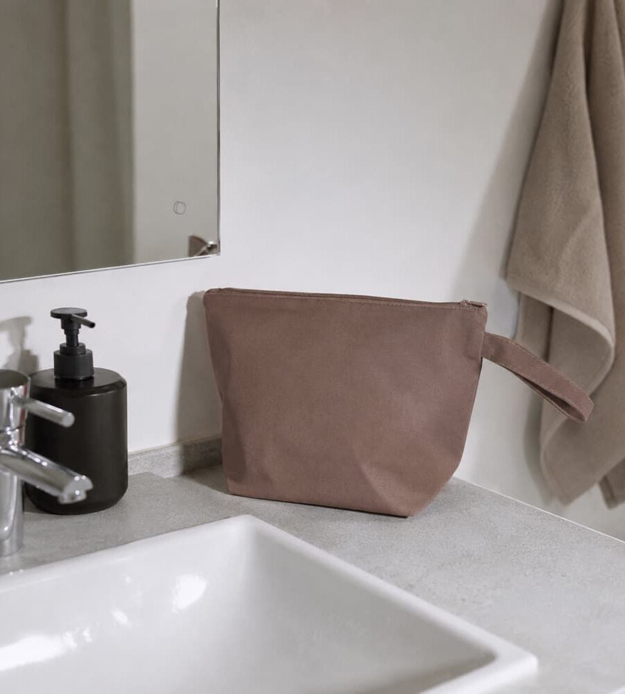 Toilettaske på badeværelsesvask ved siden af sæbedispenser